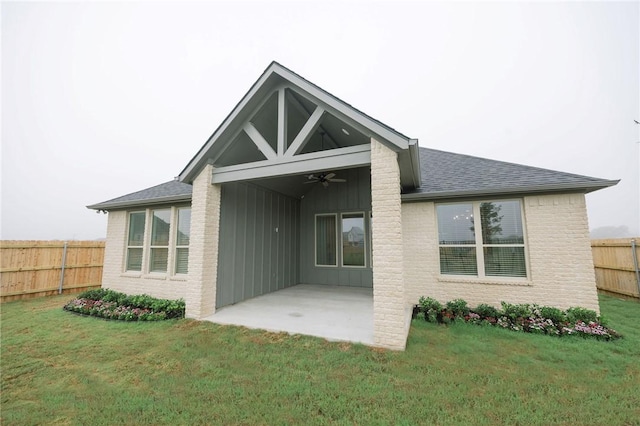 back of house with board and batten siding, a patio area, roof with shingles, ceiling fan, and a fenced backyard