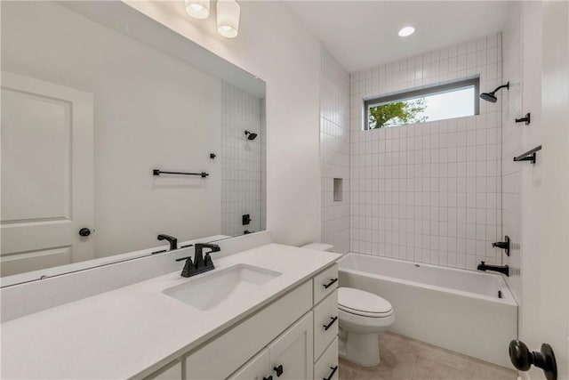 full bathroom featuring vanity, toilet, tiled shower / bath combo, and tile patterned flooring