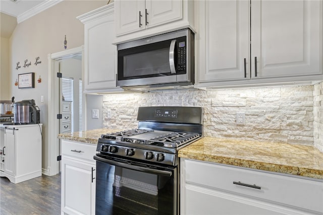 kitchen featuring white cabinetry, backsplash, black range with gas stovetop, ornamental molding, and light stone counters