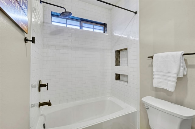 bathroom featuring tiled shower / bath and toilet