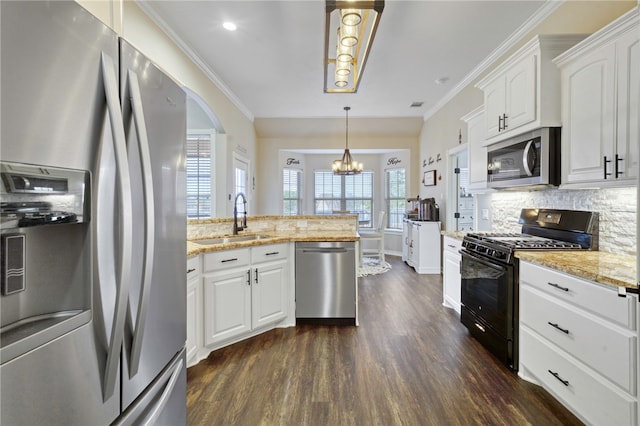 kitchen with appliances with stainless steel finishes, pendant lighting, sink, white cabinets, and light stone counters