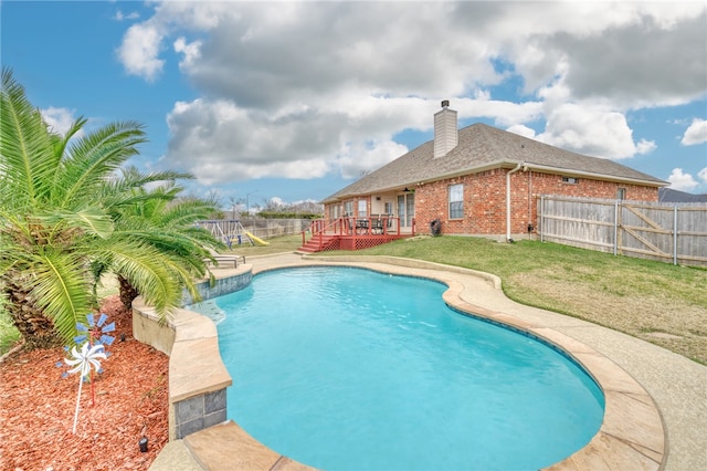 view of swimming pool featuring a deck and a lawn