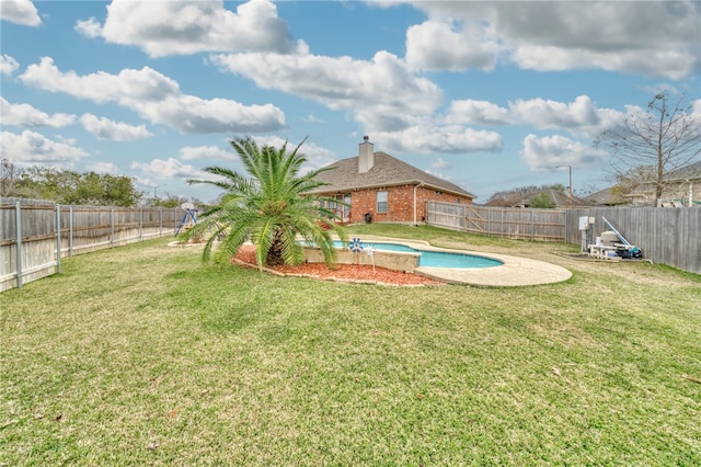 view of swimming pool featuring a yard