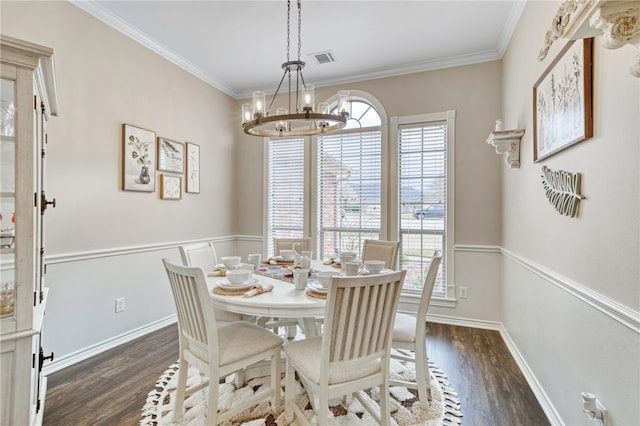 dining room featuring an inviting chandelier, crown molding, and dark hardwood / wood-style floors