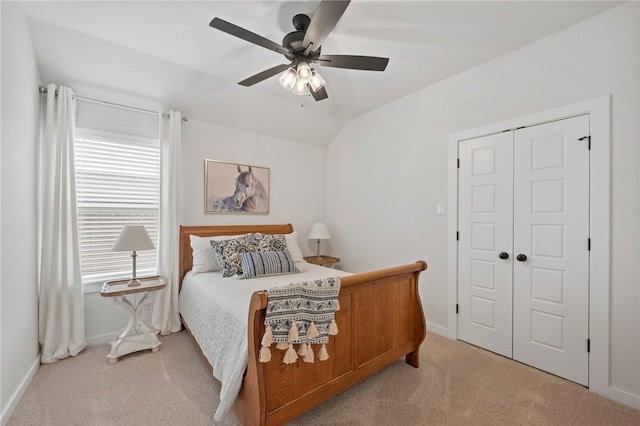 carpeted bedroom featuring ceiling fan, a closet, and vaulted ceiling