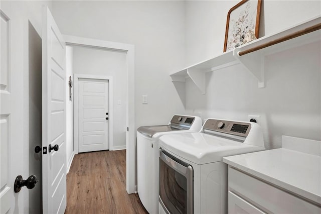 washroom featuring washing machine and dryer and light wood-type flooring