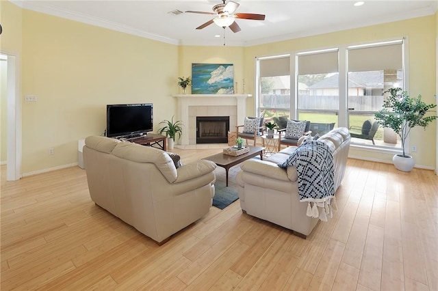 living area with light wood-type flooring, plenty of natural light, and crown molding