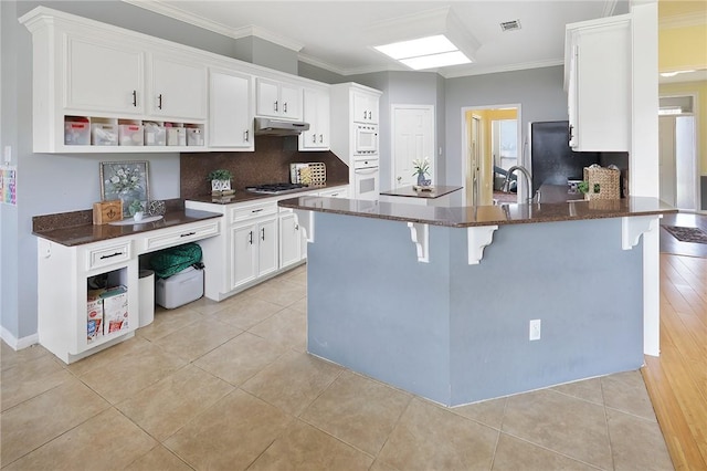 kitchen featuring ornamental molding, white cabinets, under cabinet range hood, and open shelves