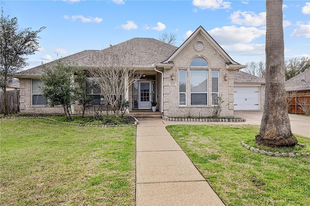 single story home featuring a front lawn, roof with shingles, fence, and brick siding