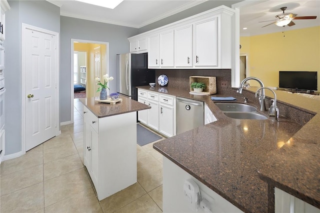 kitchen featuring light tile patterned floors, stainless steel appliances, a sink, tasteful backsplash, and crown molding