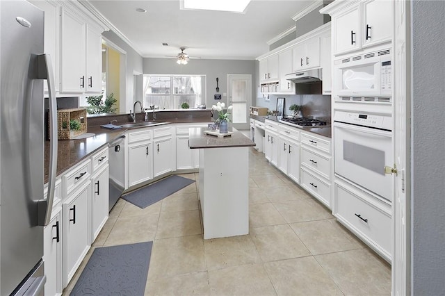 kitchen featuring a center island, stainless steel appliances, crown molding, and light tile patterned flooring