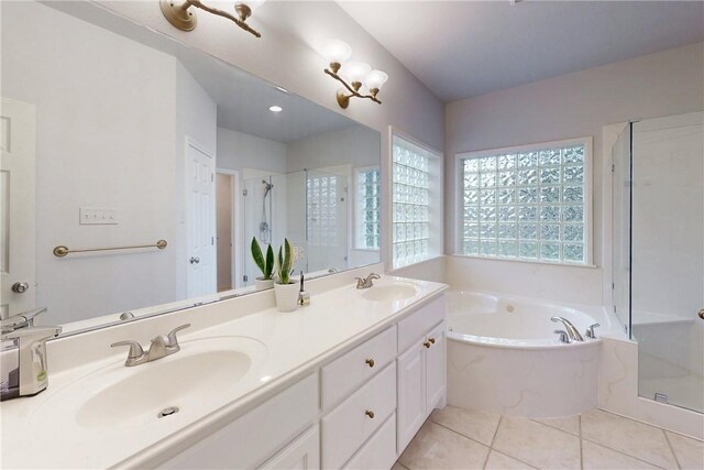 full bathroom featuring a shower stall, a bath, double vanity, and tile patterned flooring