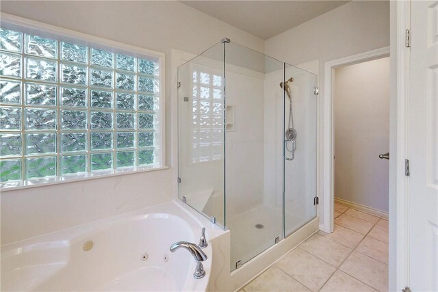 full bath with a stall shower, tile patterned floors, and a tub with jets