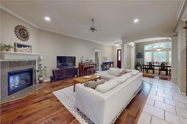 living area featuring ornate columns, ornamental molding, arched walkways, recessed lighting, and ceiling fan
