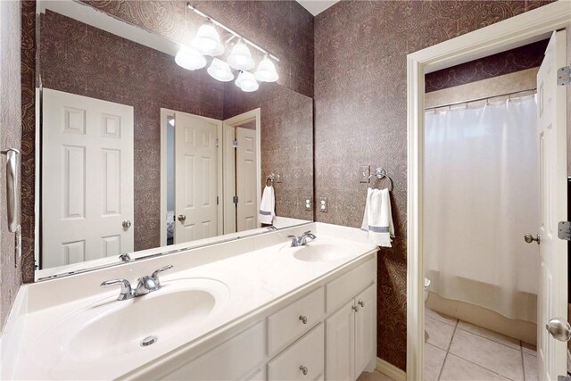 bathroom with double vanity, curtained shower, tile patterned flooring, wallpapered walls, and toilet