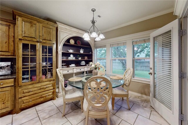 dining room with light tile patterned flooring, a chandelier, crown molding, and baseboards