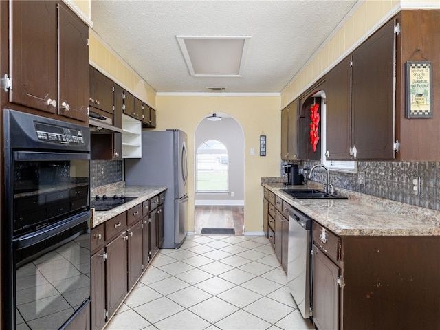 kitchen featuring backsplash, sink, black appliances, and a textured ceiling