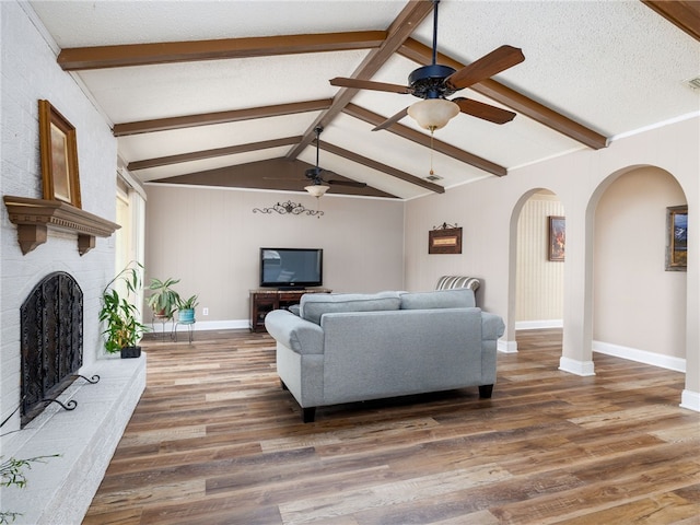 living room featuring lofted ceiling with beams, a textured ceiling, dark hardwood / wood-style floors, and ceiling fan