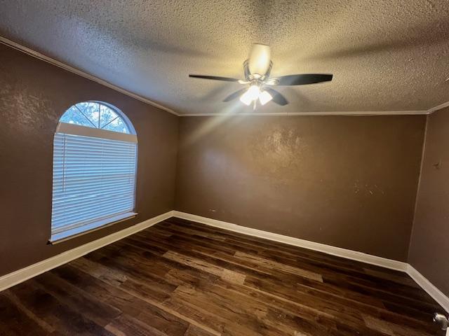 empty room featuring a textured ceiling, ceiling fan, dark hardwood / wood-style flooring, and crown molding