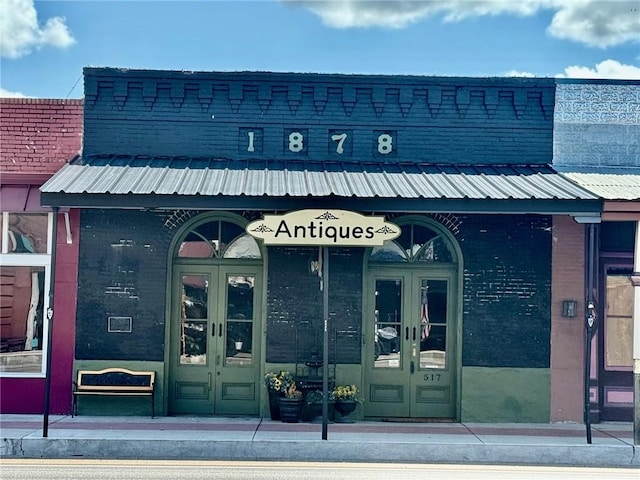 517 S Main St, Calvert, TX 77837 - doorway to property featuring french doors, metal roof, and a surveillance system