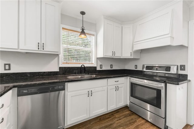 3614 Oak Ridge Dr, Bryan, TX 77802 - kitchen with stainless steel appliances, custom range hood, white cabinetry, dark wood-type flooring, and hanging light fixtures