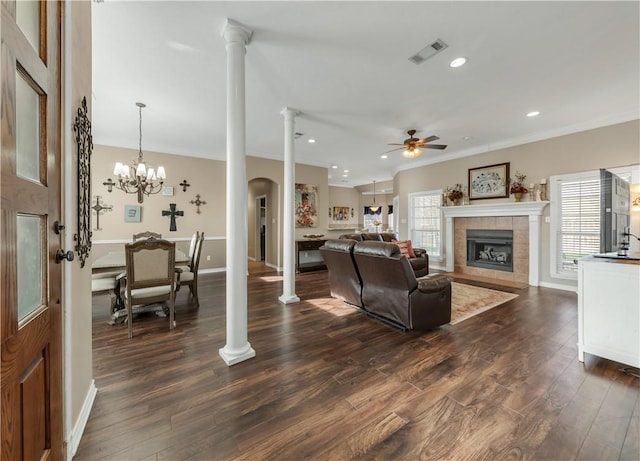 living area with plenty of natural light, decorative columns, a fireplace, and visible vents