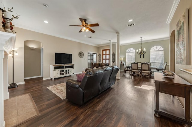 living room with dark wood-style floors, arched walkways, crown molding, visible vents, and ornate columns