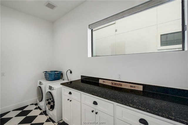 clothes washing area featuring washer and dryer and cabinets