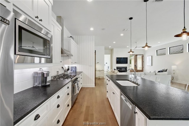 kitchen with white cabinets, stainless steel appliances, a large island, and sink