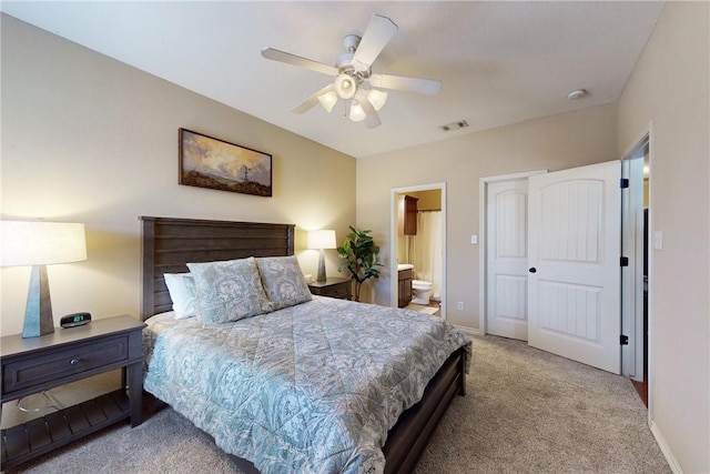 carpeted bedroom with a closet, ensuite bath, and ceiling fan