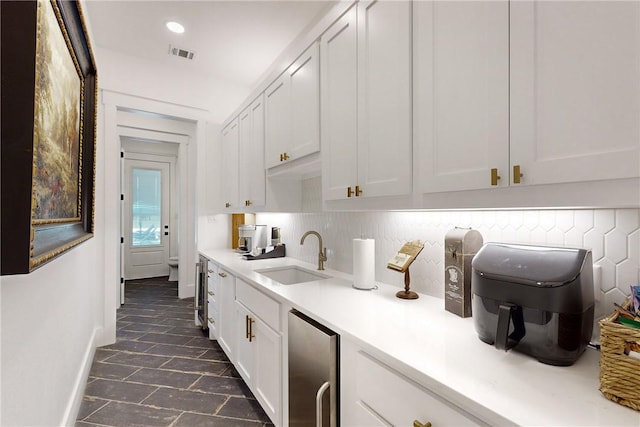 1981 County Road 202, Caldwell, TX 77836 - kitchen featuring a sink, light countertops, white cabinetry, stainless steel fridge, and baseboards