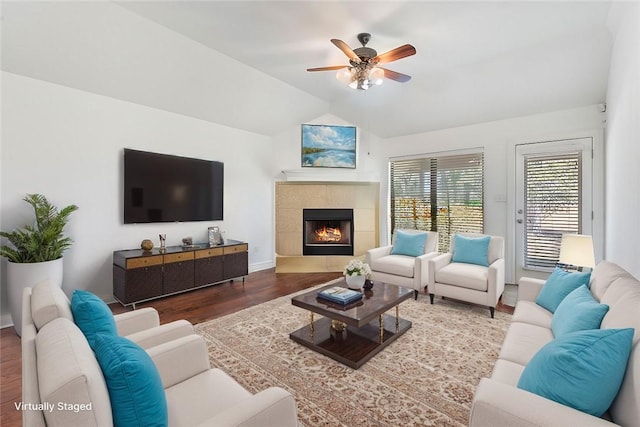 living room featuring ceiling fan, a fireplace, wood-type flooring, and vaulted ceiling