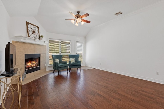 living area with ceiling fan, crown molding, a fireplace, dark hardwood / wood-style floors, and lofted ceiling