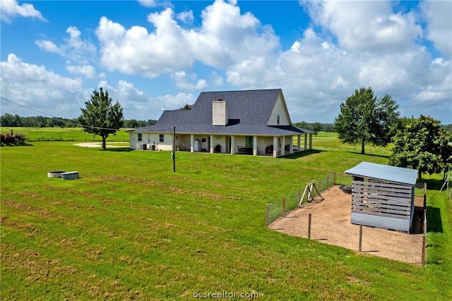 rear view of house featuring a yard