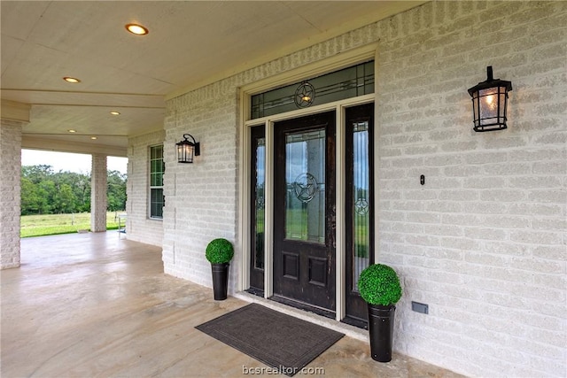 view of exterior entry featuring covered porch