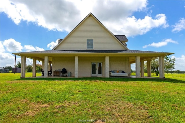 back of house featuring a yard, french doors, and a patio