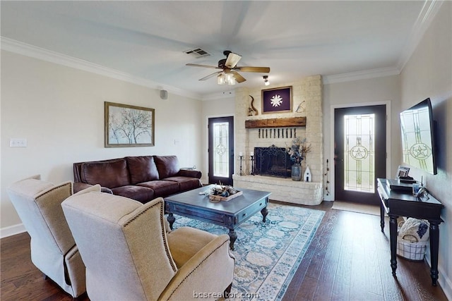 living room featuring ceiling fan, dark hardwood / wood-style flooring, ornamental molding, and a fireplace