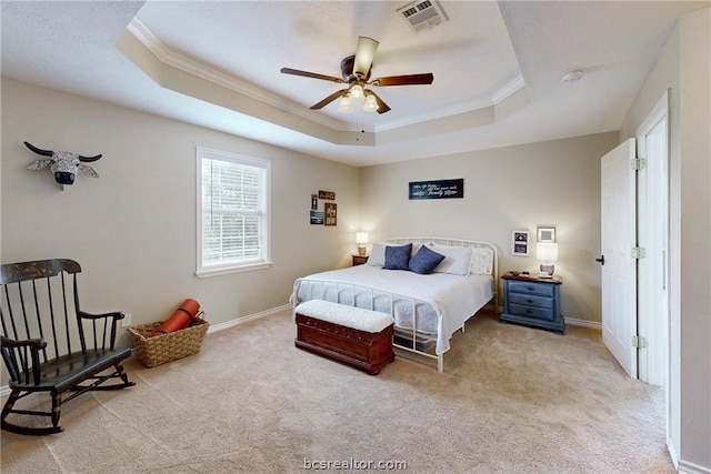 bedroom with a tray ceiling, ceiling fan, and light carpet