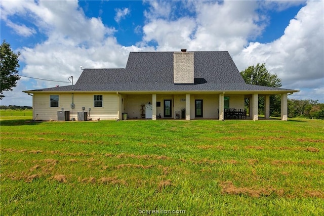 rear view of property featuring a lawn, a patio area, and central air condition unit