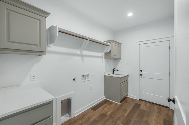 laundry area featuring hookup for a washing machine, hookup for an electric dryer, dark hardwood / wood-style flooring, sink, and cabinets