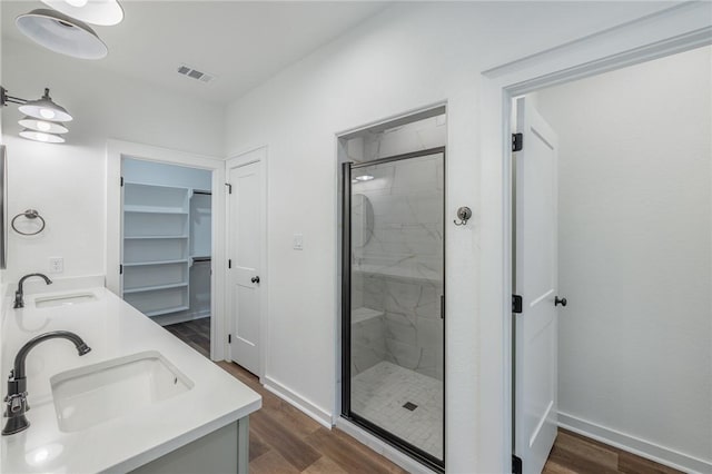 bathroom featuring hardwood / wood-style floors, vanity, and a shower with door