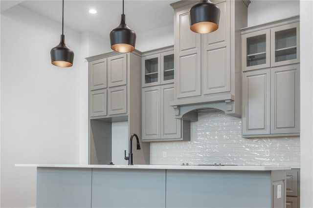 kitchen with sink, backsplash, gray cabinets, and decorative light fixtures