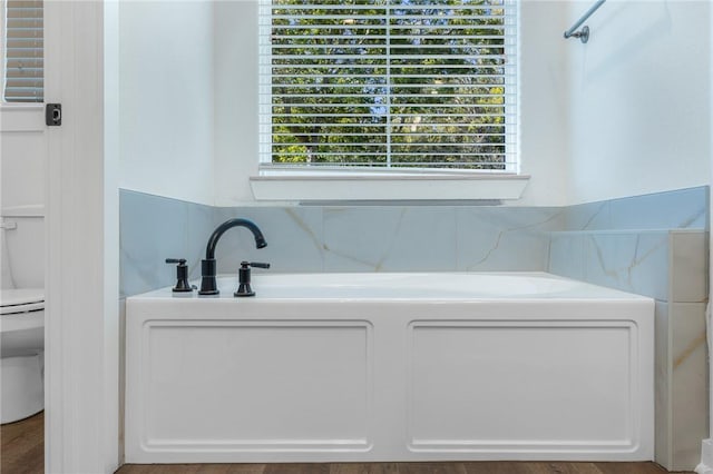 bathroom with a baseboard radiator, toilet, and a bathing tub