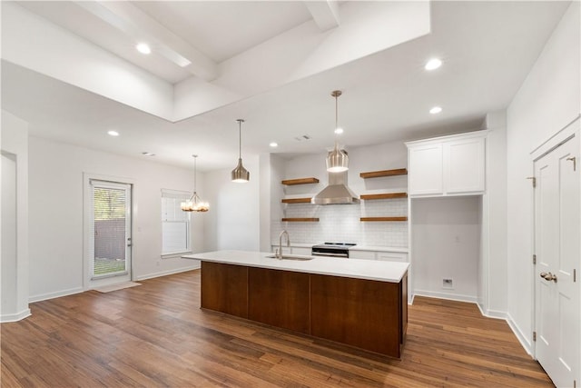 kitchen featuring dark hardwood / wood-style flooring, stainless steel range with electric stovetop, a center island with sink, white cabinets, and hanging light fixtures