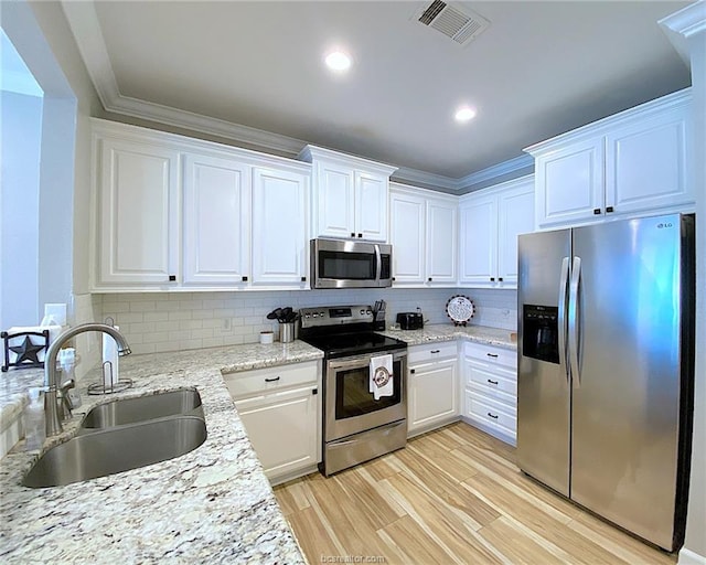 801 Luther St W Unit 1407, College Station, TX 77840 - kitchen featuring stainless steel appliances, a sink, white cabinets, recessed lighting, and ornamental molding