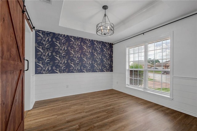 2308 Kuykendall Cir, Bryan, TX 77808 - spare room with a barn door, wainscoting, a chandelier, wood finished floors, and wallpapered walls