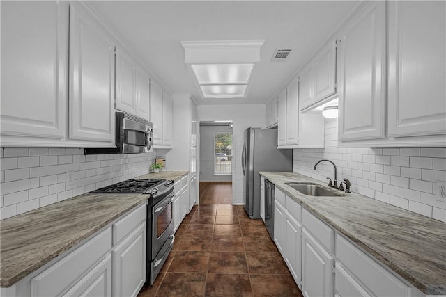 2308 Kuykendall Cir, Bryan, TX 77808 - kitchen with appliances with stainless steel finishes, white cabinetry, backsplash, and light stone countertops