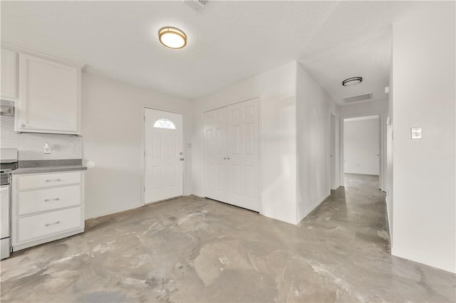 kitchen featuring white cabinets, decorative backsplash, range, and a textured ceiling