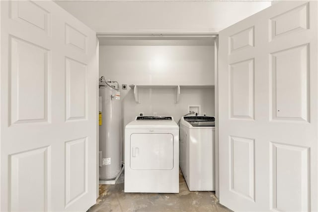 clothes washing area with washing machine and dryer and water heater