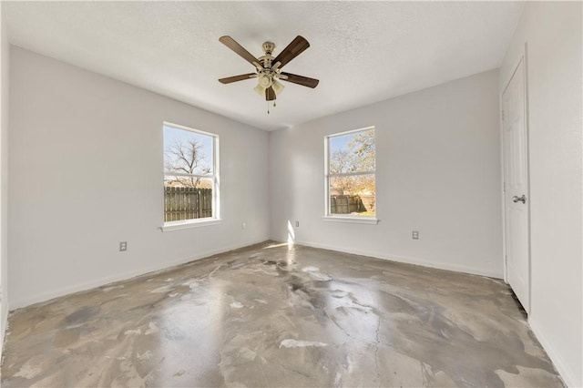 spare room featuring ceiling fan, concrete flooring, and a textured ceiling